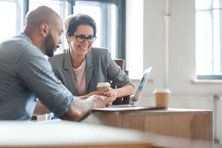 woman-in-glasses-with-man-at-laptop-1 man and woman looking at laptop